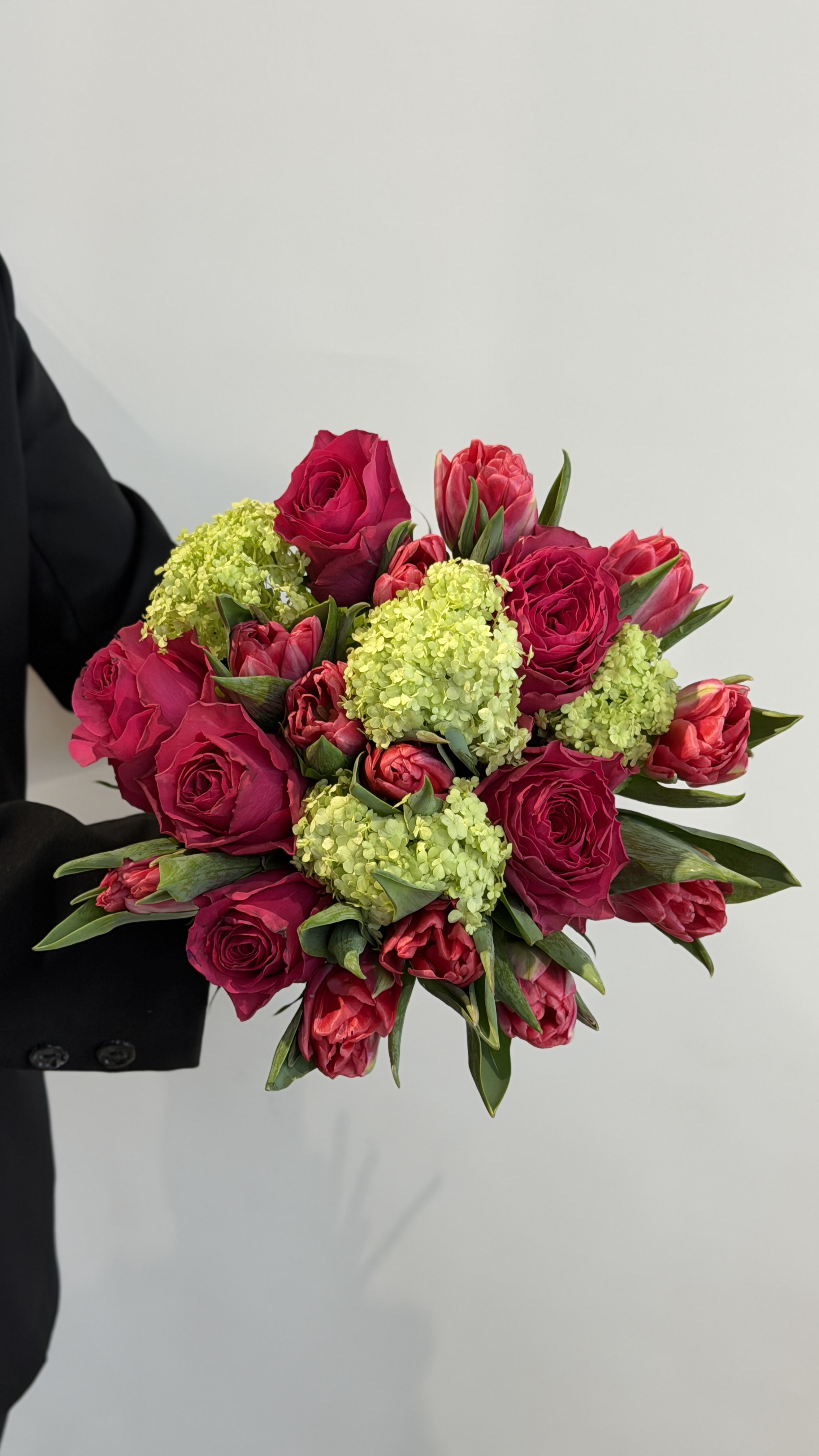 Букет з малинових троянд, піоноподібних тюльпанів та зеленого вібурнуму