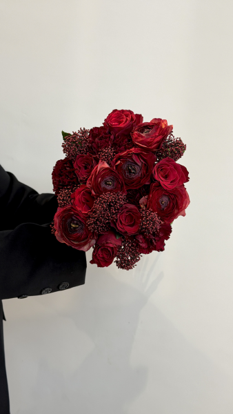 Букет з червоних ранункулюсів, троянд та гвоздик зі скімією